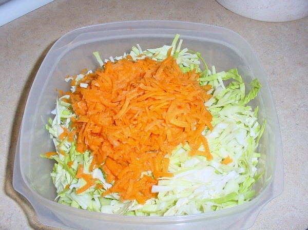 shredded cabbage and shredded carrots in a mixing bowl