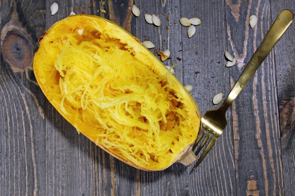 Cooked spaghetti squash cut in half on a table