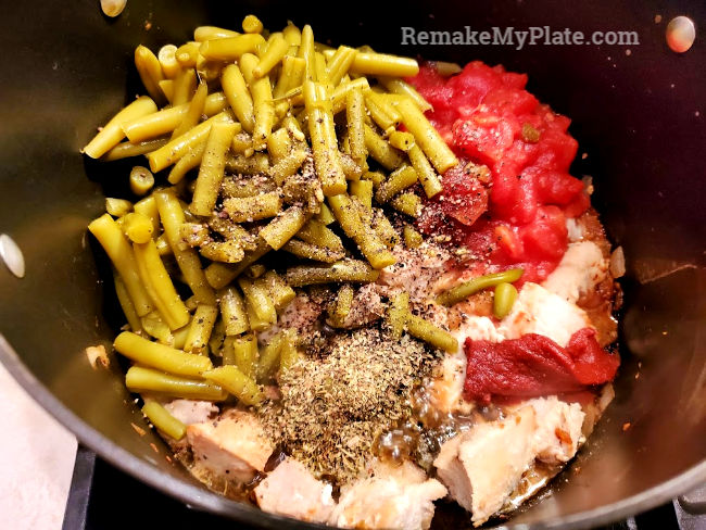 Green beans, tomatoes and spices added to stew pot