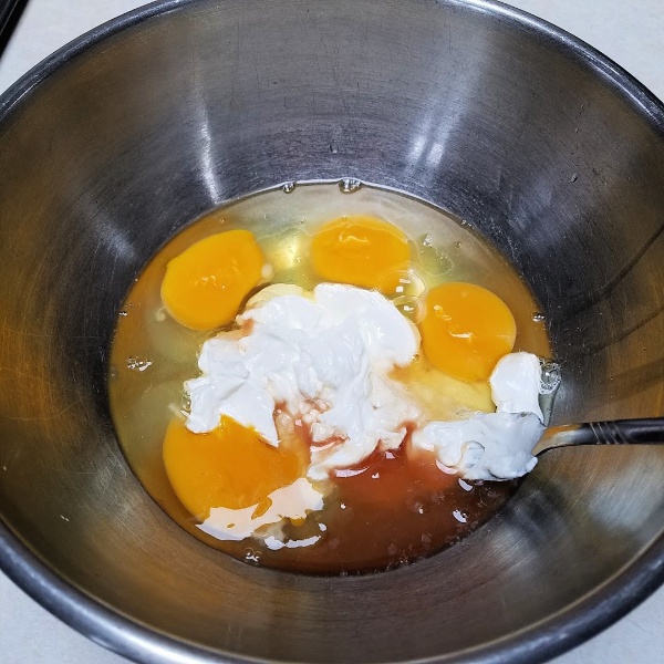 mixing the eggs and sour cream in a bowl