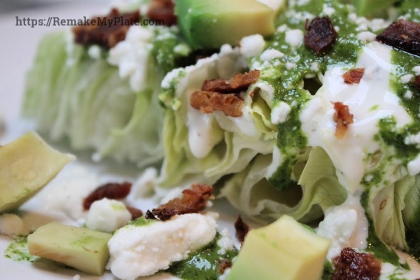 close up of Iceberg wedge salad topped with ranch and chimichurri dressing