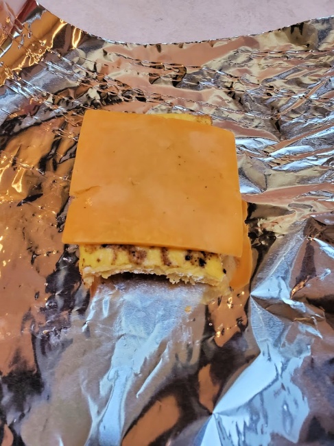 slice of cheese on top of breakfast sandwich