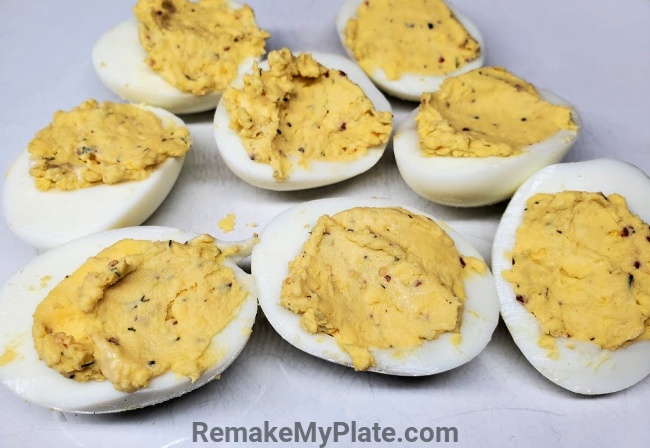 Adding in the mashed yolk mixture to the deviled eggs