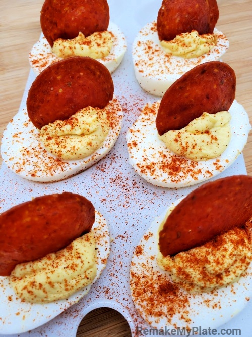 delicious deviled eggs with a creamy filling and topped with pepperoni on a tray