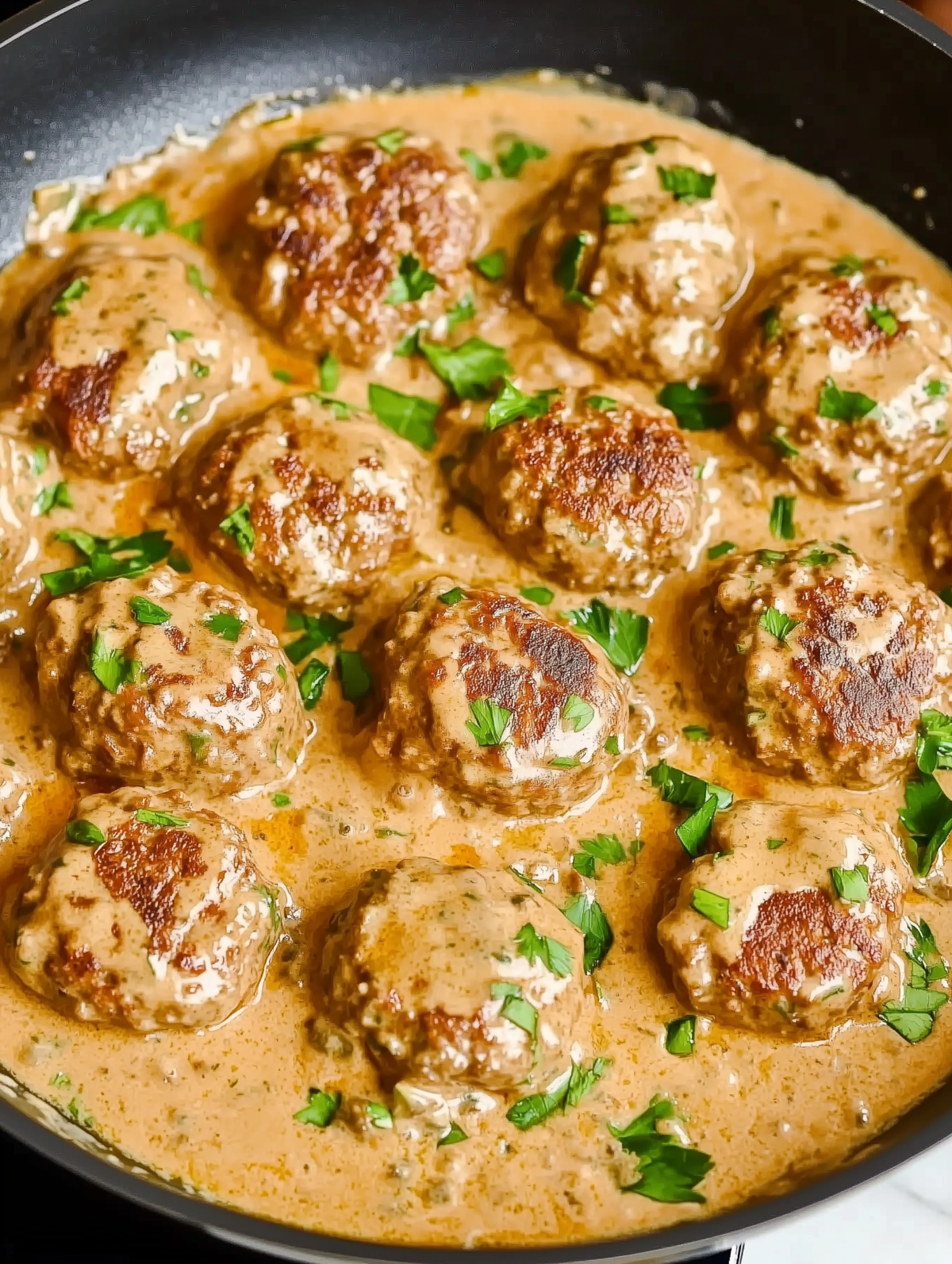 keto feta burgers in a cream sauce in a skillet