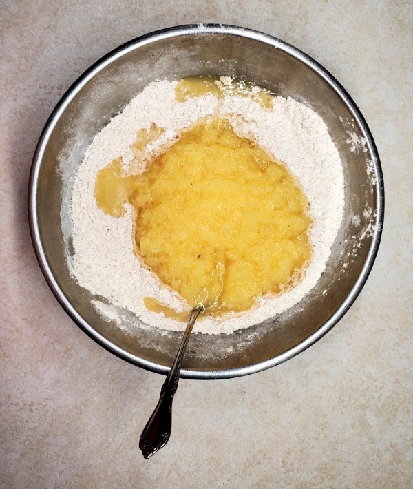 Mixing in the pineapple with the juice and the vanilla extract into the dry ingredients