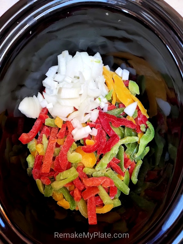 Adding peppers and onions to the bottom of the crockpot