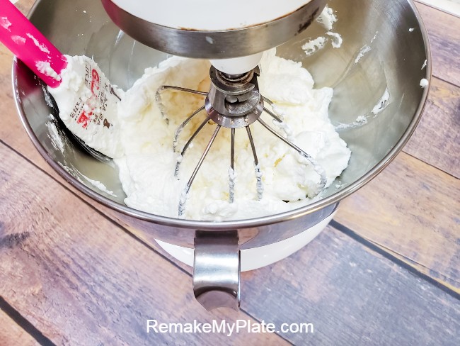 Scrapping down the sides of the bowl of your stand mixer once the cream has stiff peaks 