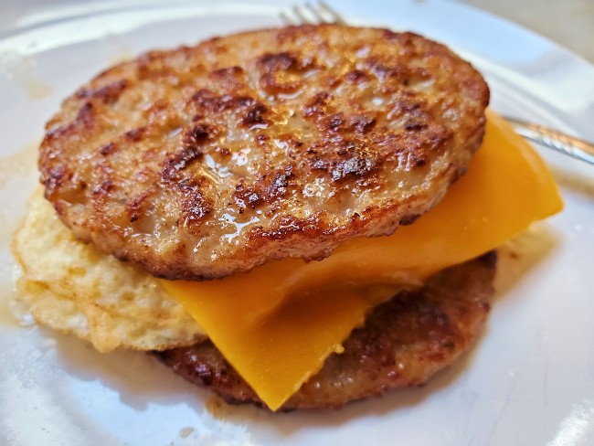 keto breakfast sandwich made with sausage in place of buns