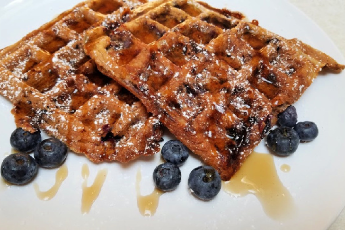 keto blueberry chaffles on a plate topped with sugarfree maple syrup