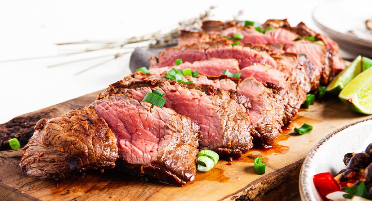 easy to make marinated flat iron steak sliced on a cutting board