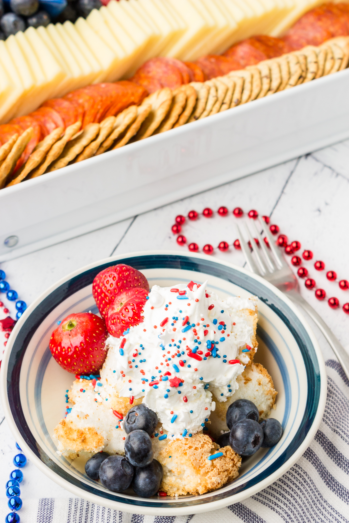 berry cakes on a plate with whipped topping and sprinkles