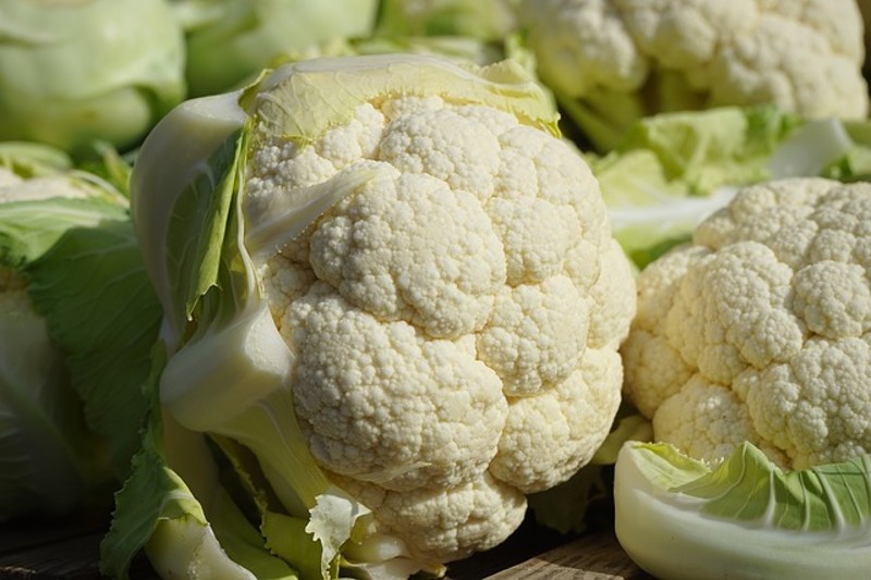 heads of cauliflower on display at a farmers market