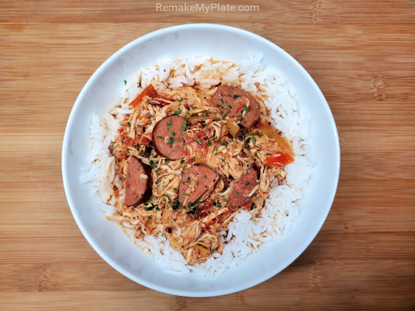 bowl filled with rice topped with slow cooker cajun chicken and sausage