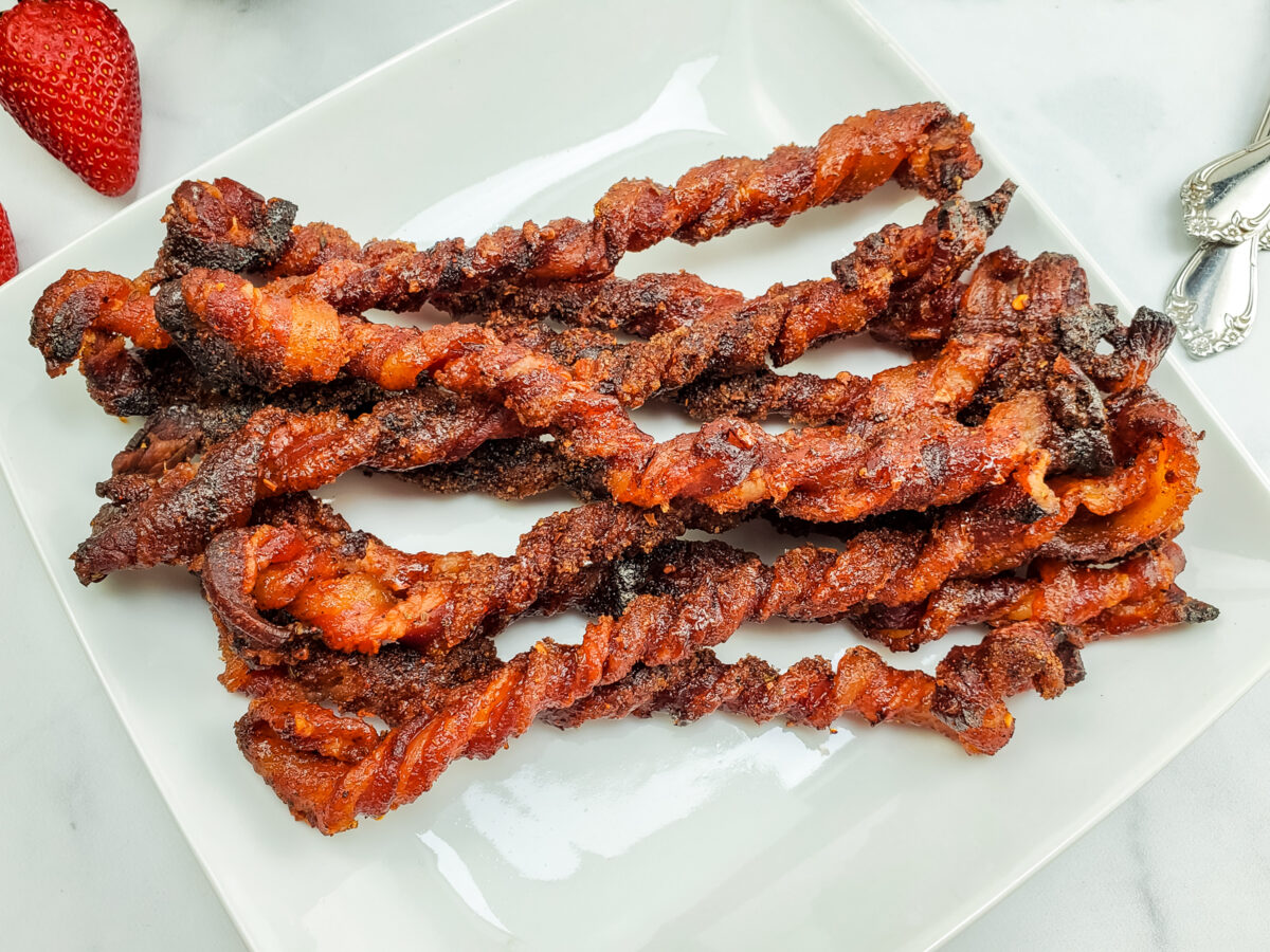 slices of candied twisted bacon on a breakfast plate
