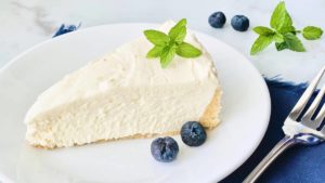 Keto No Bake Cheesecake featured closeup slice of cheesecake with blueberries e1634847133307