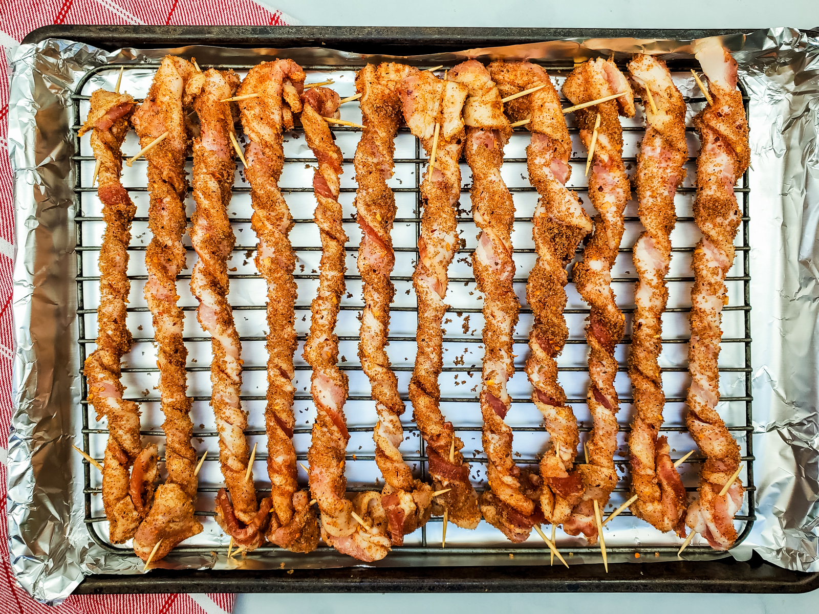 twisted pieces of bacon on a baking rack