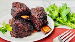 Smoked Beef Short Ribs featured close up on a plate with parsley and fork to the right e1629656402716.jpgfit12002c676ssl1