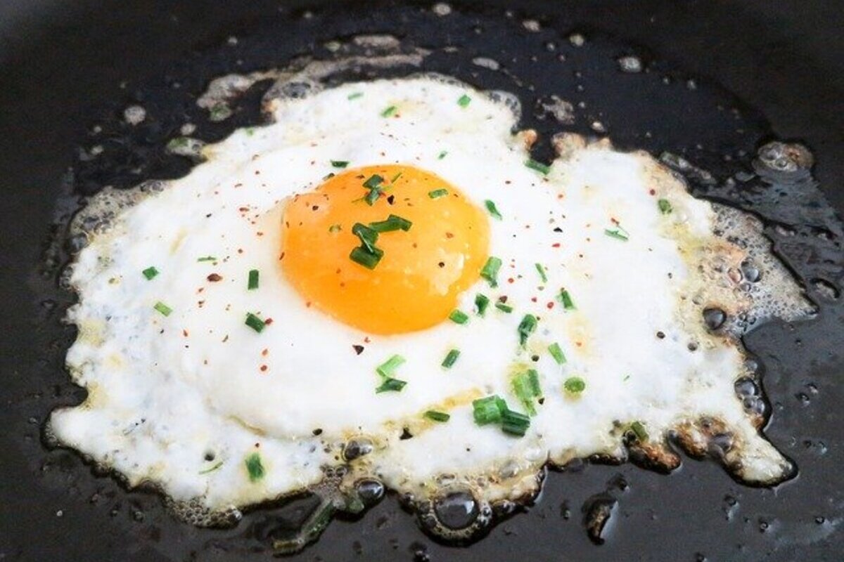 fried egg sunny side up cooking in a pan