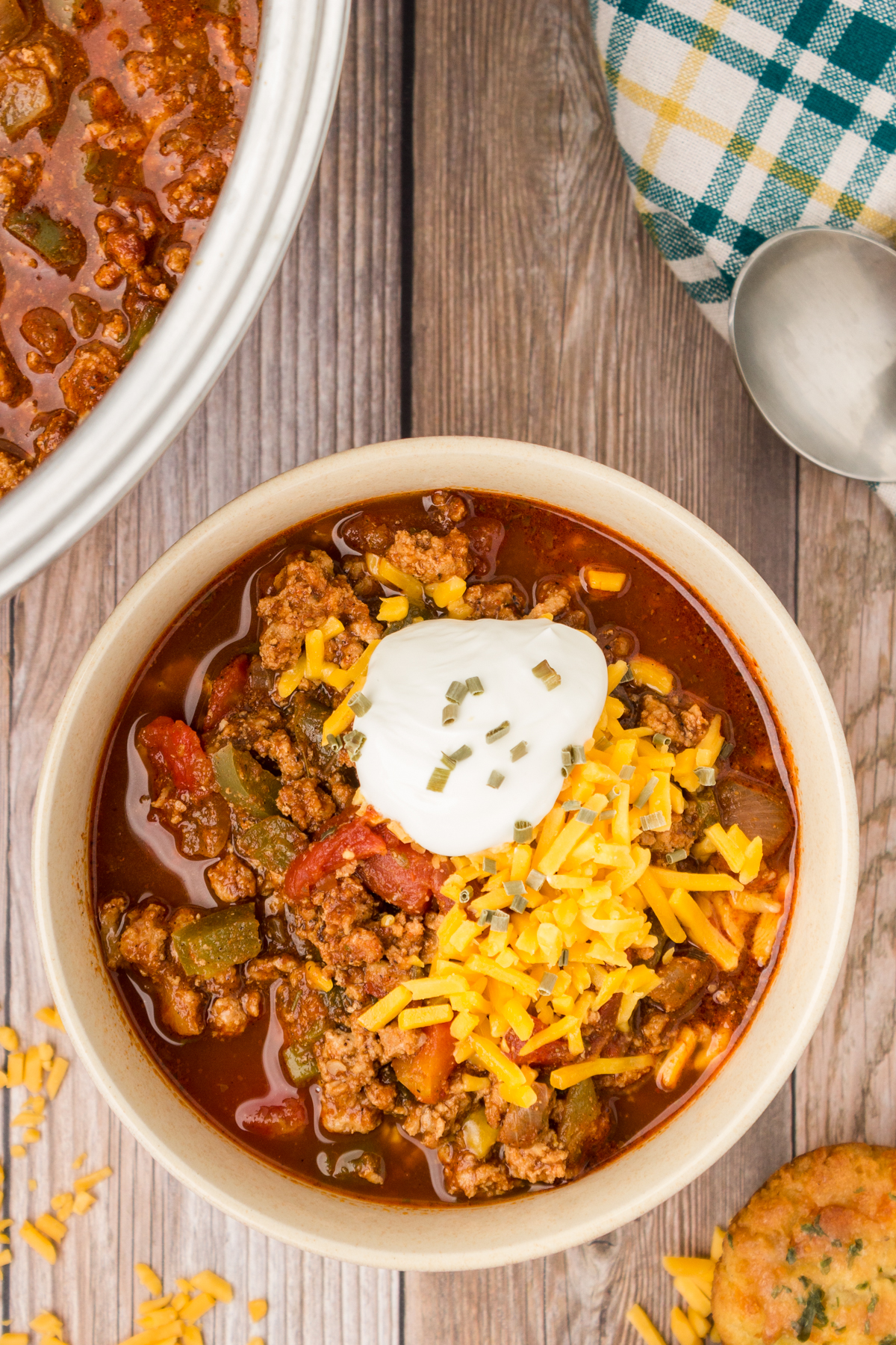 no beans turkey chili topped with shredded cheese and sour cream in a bowl