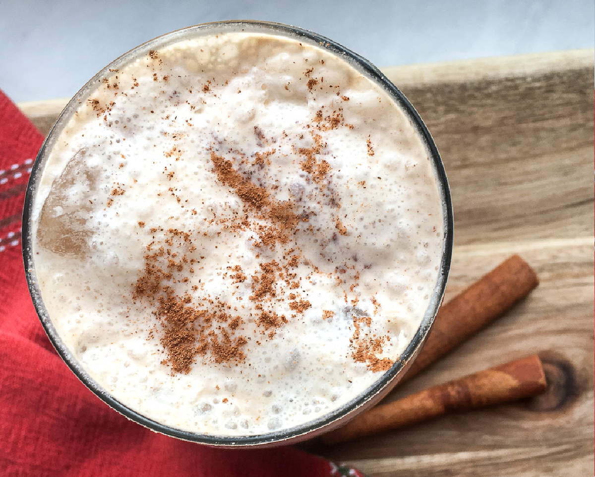 dairy free horchata drink on a table with a cinnamon stick to stir it