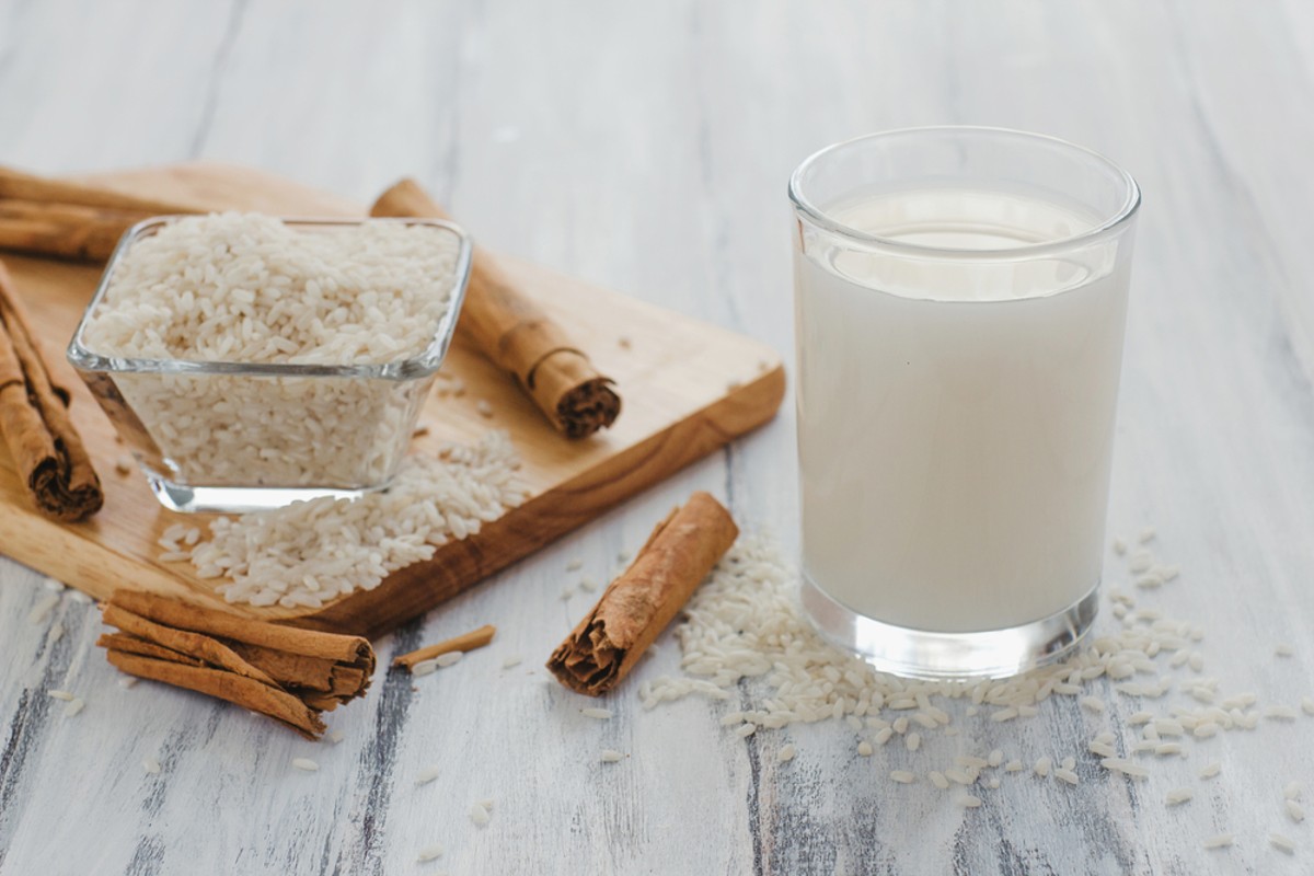 healthy homemade horchata drink on table with rice and cinnamon sticks