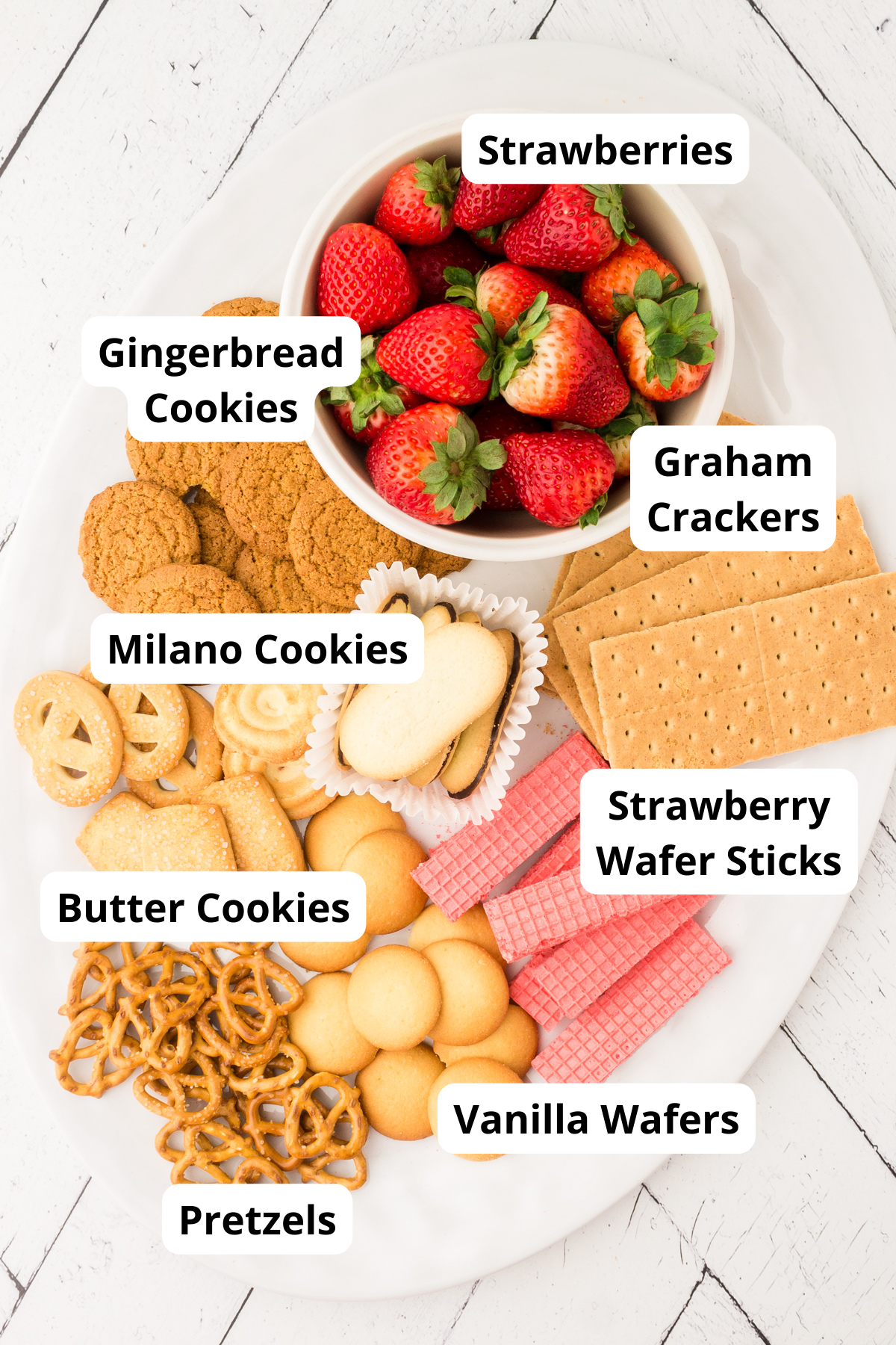 variety of cookies, pretzels and strawberries on a platter to use as dippers