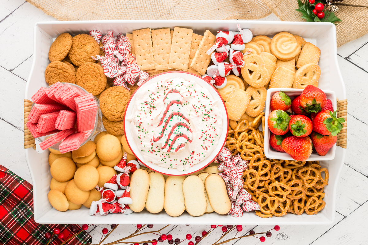 christmas tree dip charcuterie board with cookie and fruit dippers displayed on a table