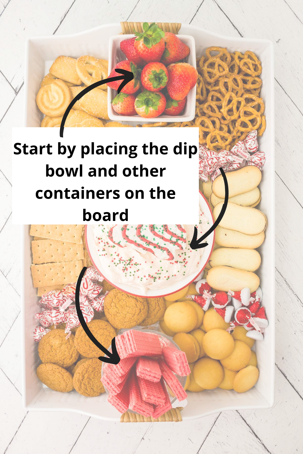 to make this dessert board begin by placing the dip bowl and other containers on the board