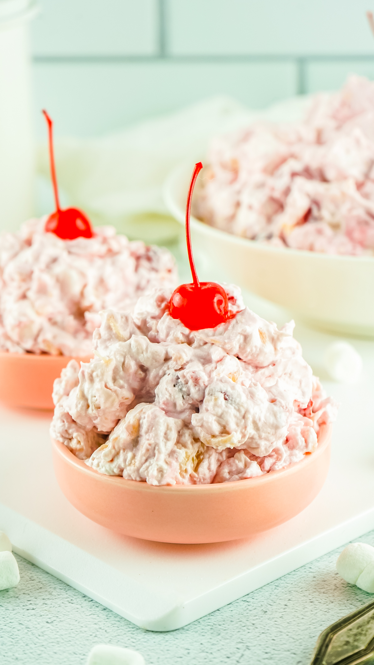 easy to make cherry fluff salad served in bowls and topped with maraschino cherries