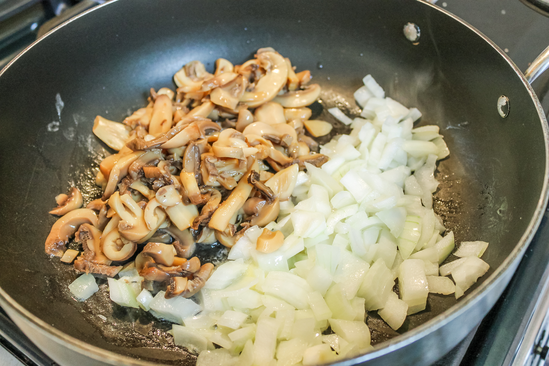 mushrooms and onions cooking in a skillet