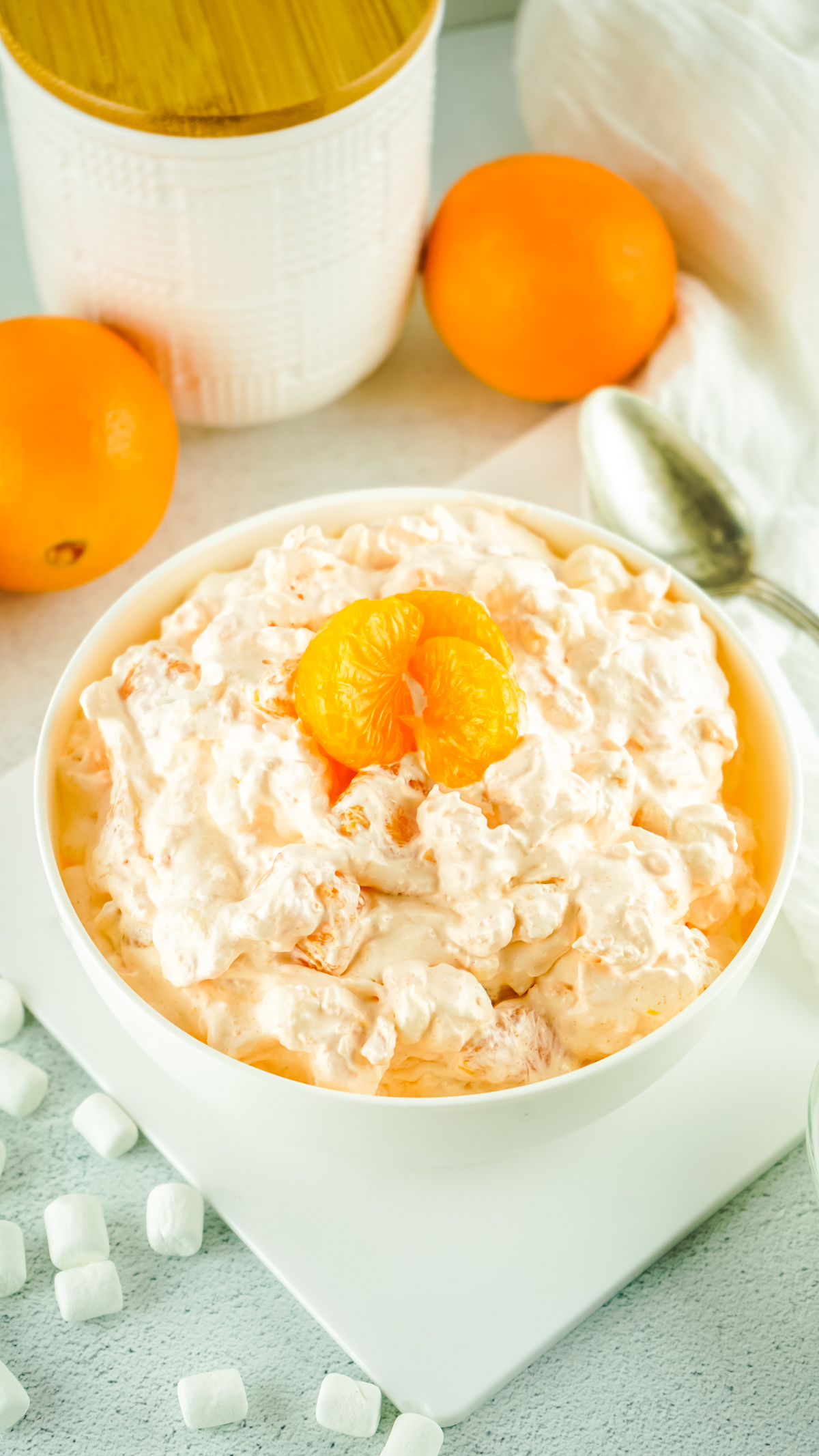 easy recipe to make orange fluff salad served in bowls and topped with mandarin oranges
