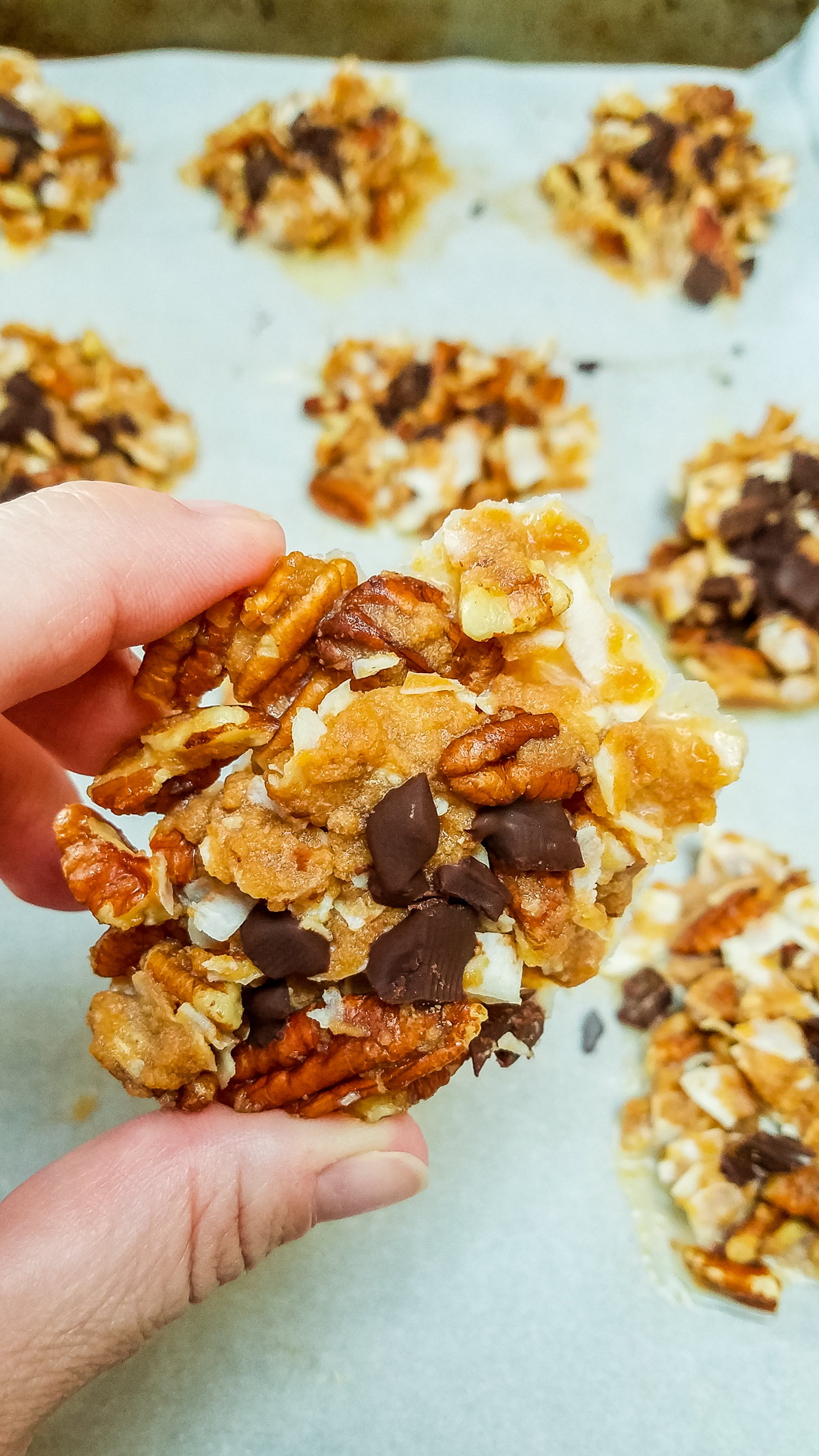 holding a keto sugar free praline made with pecans, almonds and coconut