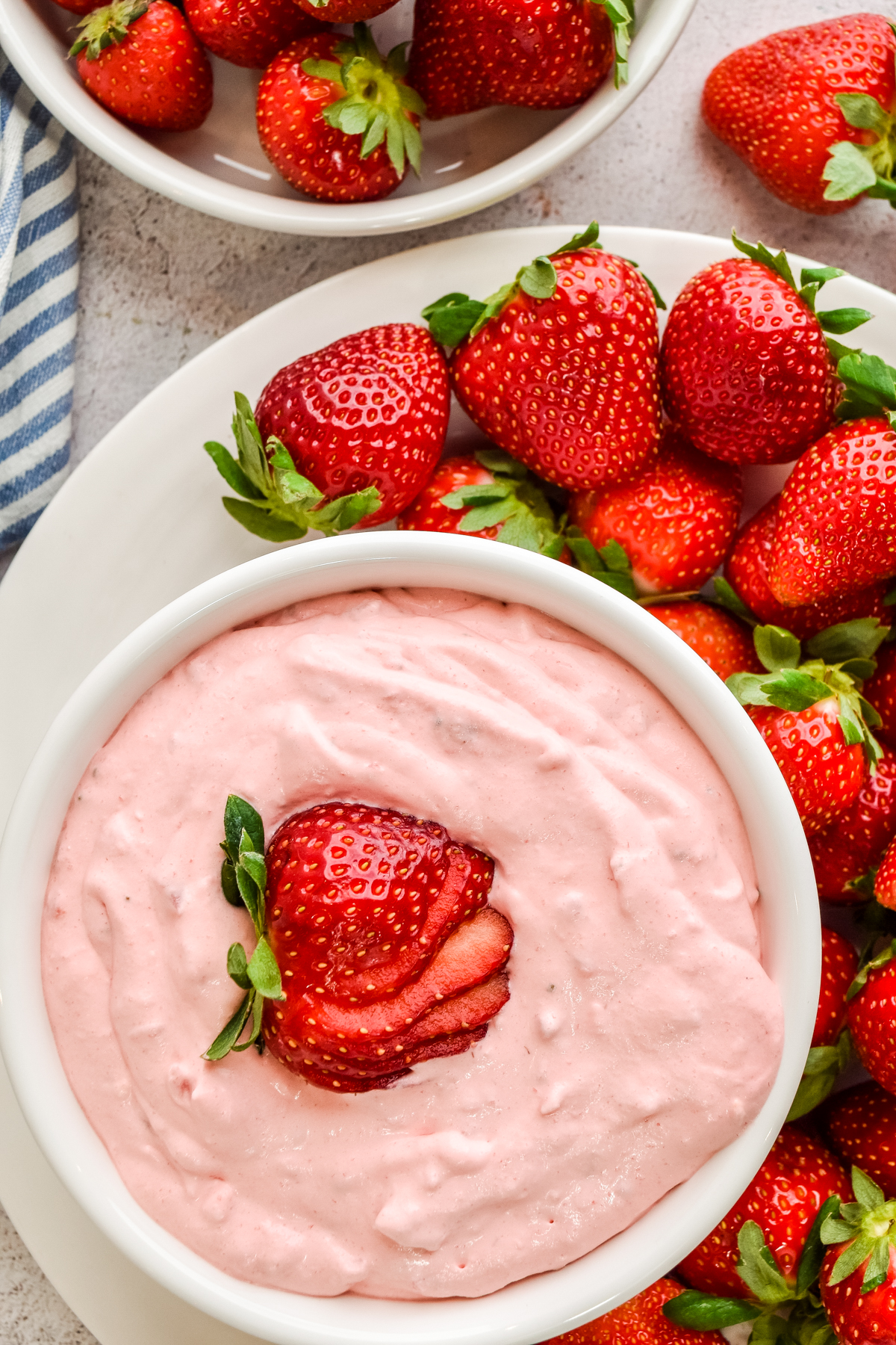 strawberry fluff easy dessert salad in a bowl topped with sliced strawberries