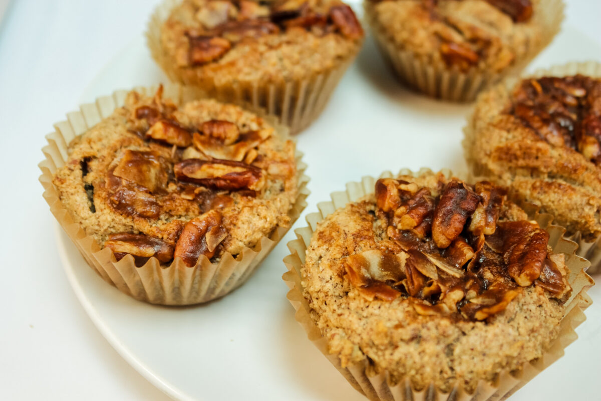 keto cinnamon praline muffins on a plate topped with keto pecan pralines