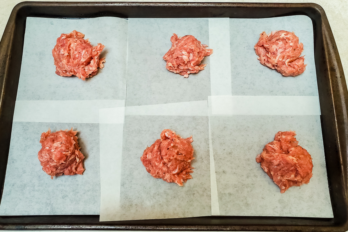 a scoop of breakfast sausage mixture is placed on each square of waxed paper