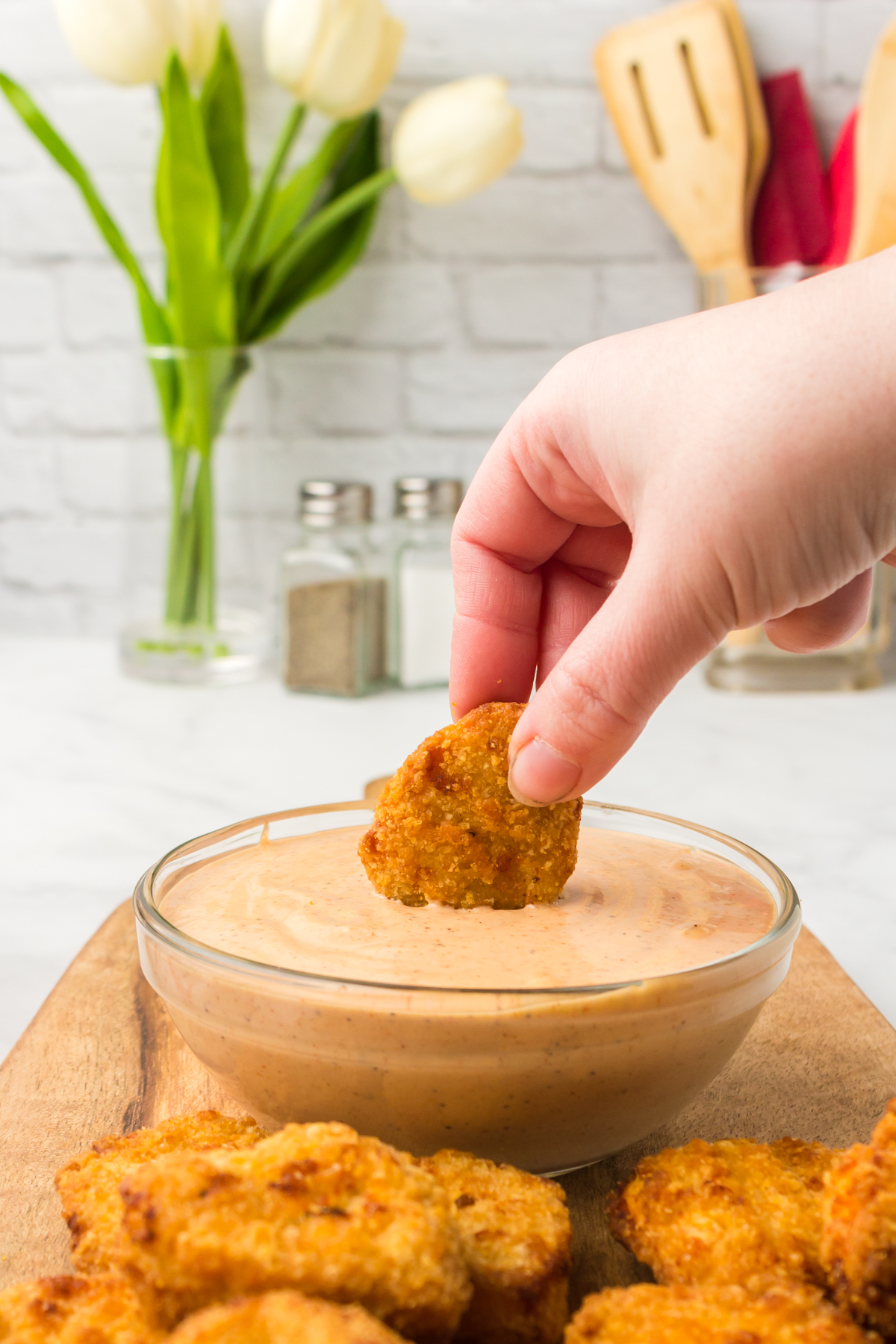 Chicken nugget being dipped in this perfect condiment sauce