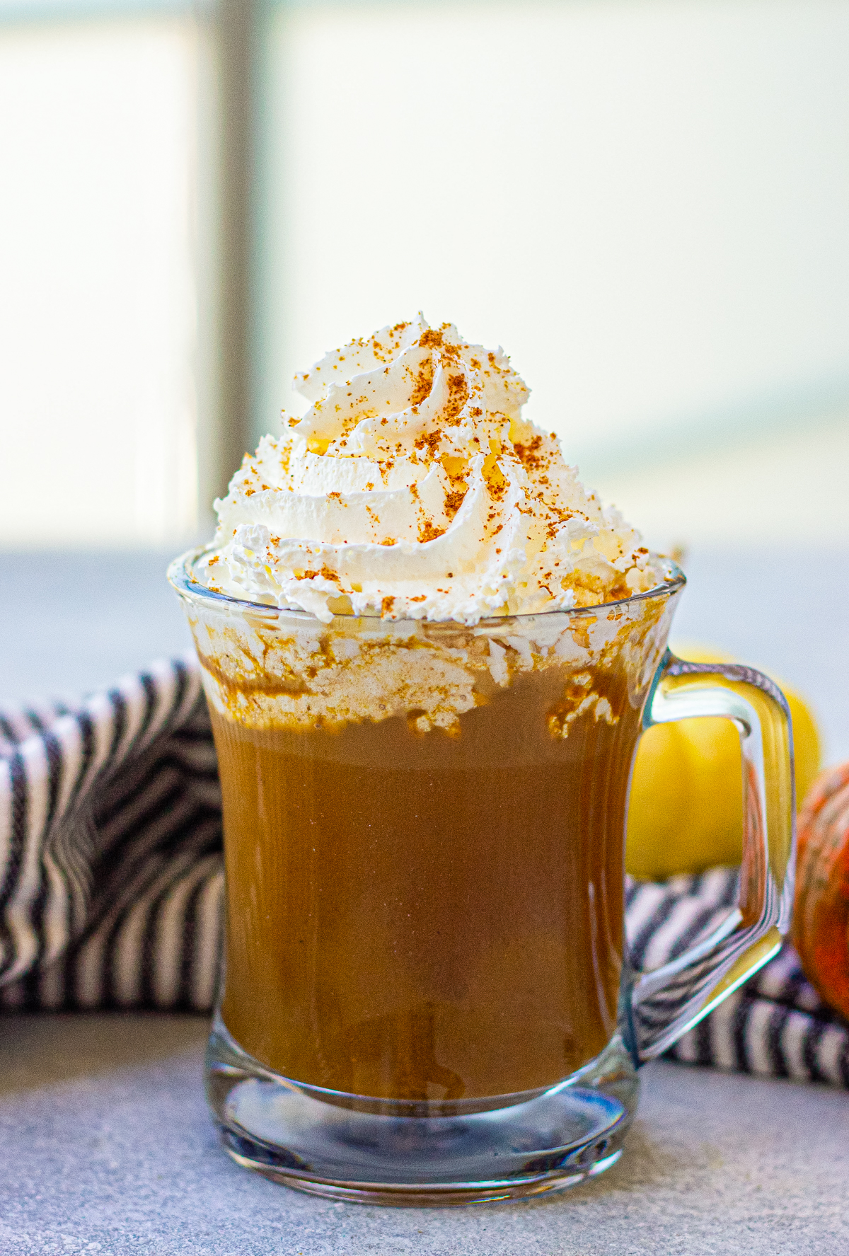 delicious copycat starbucks pumpkin spice latte with whipped cream topping in a glass mug