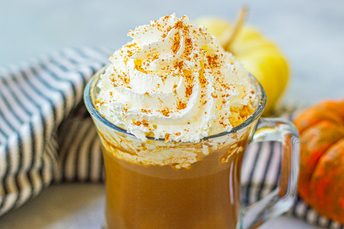 mug full of pumpkin spice homemade latte topped with whipped cream 