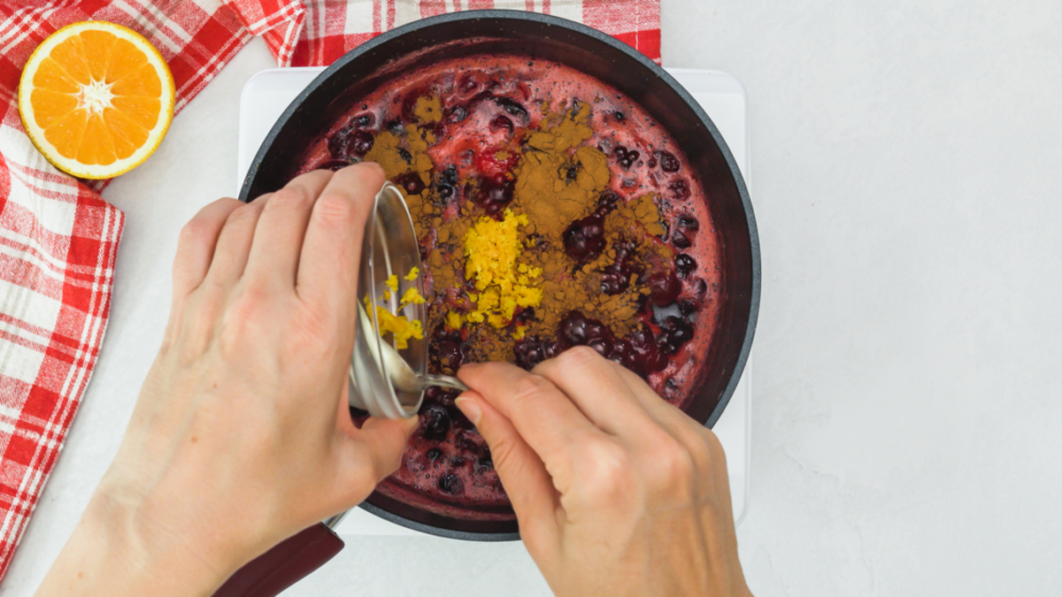 stirring in orange zest and cinnamon into this best cranberry sauce recipe