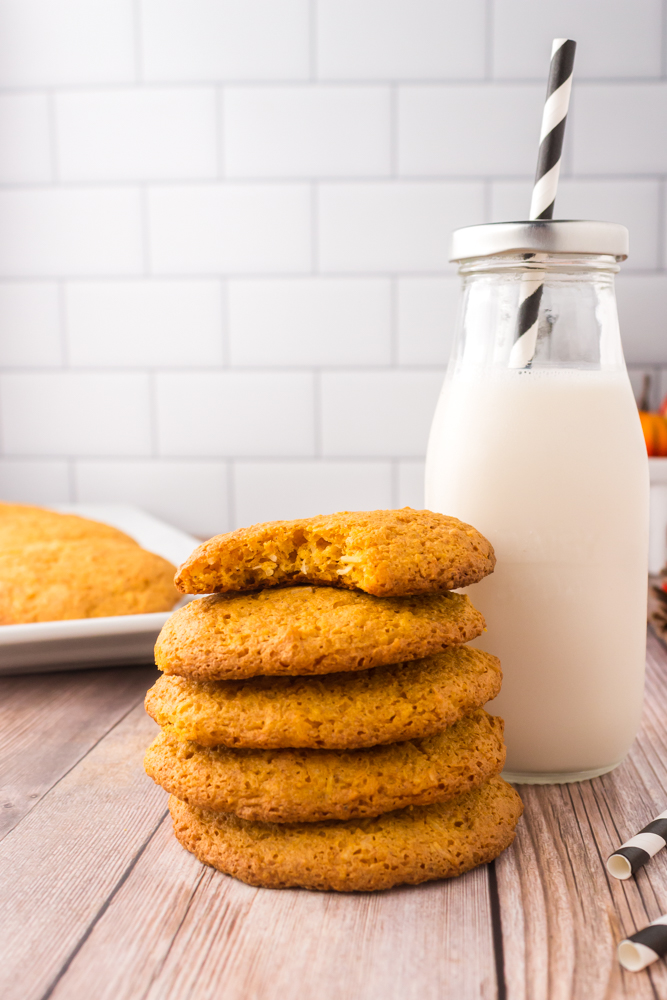 pumpkin angel food cake cookies stacked next to a bottle of milk