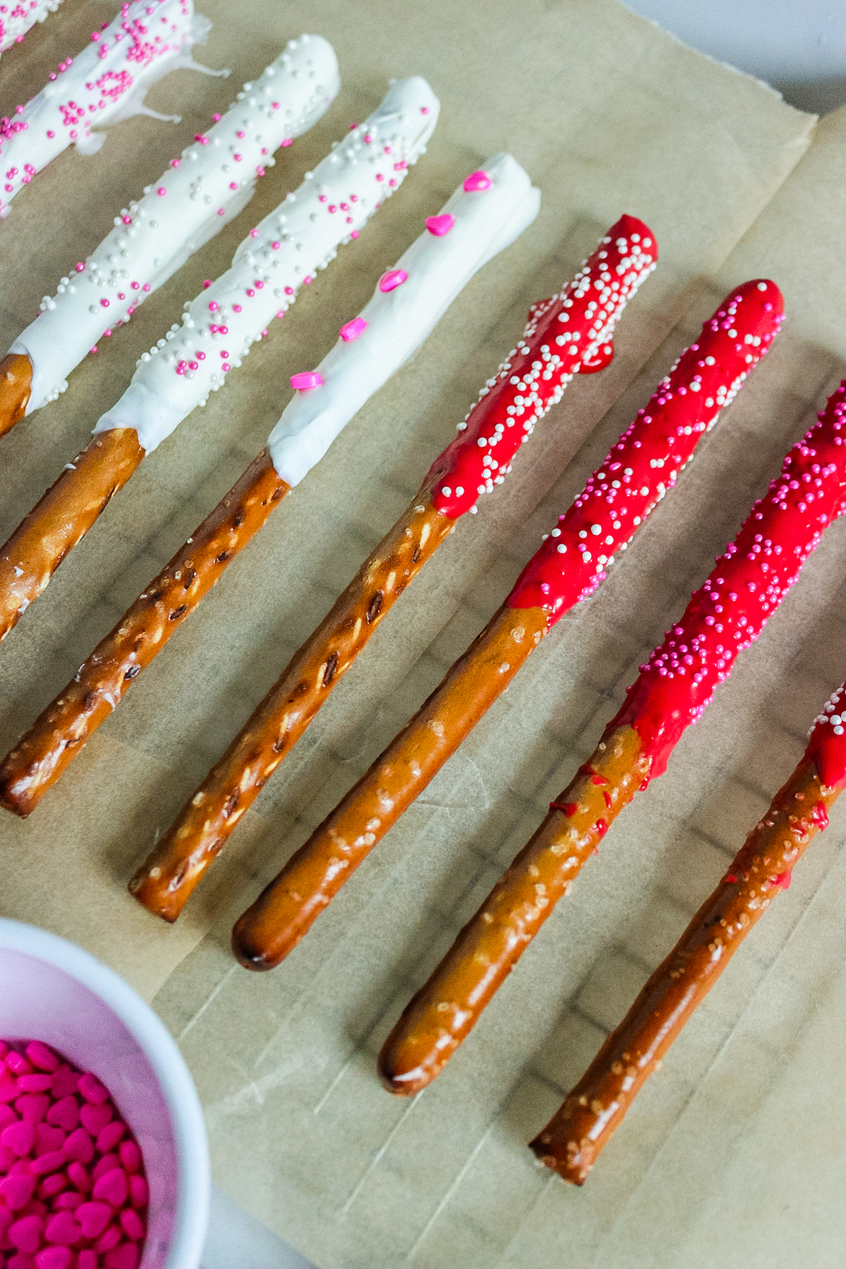 chocolate dipped pretzel rods on parchment paper lined baking sheet