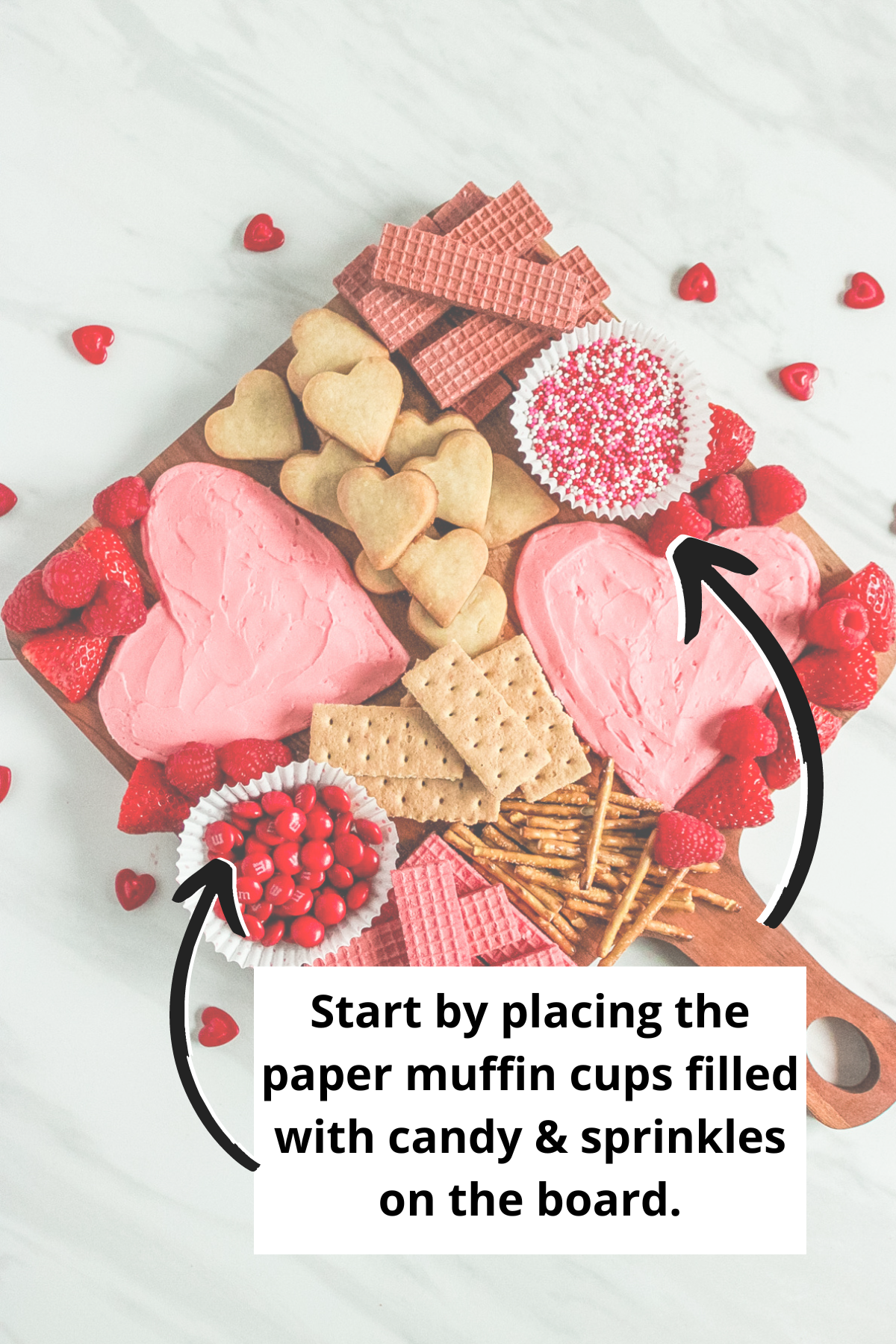 placing paper muffin cups filled with candies and sprinkles on the charcuterie board