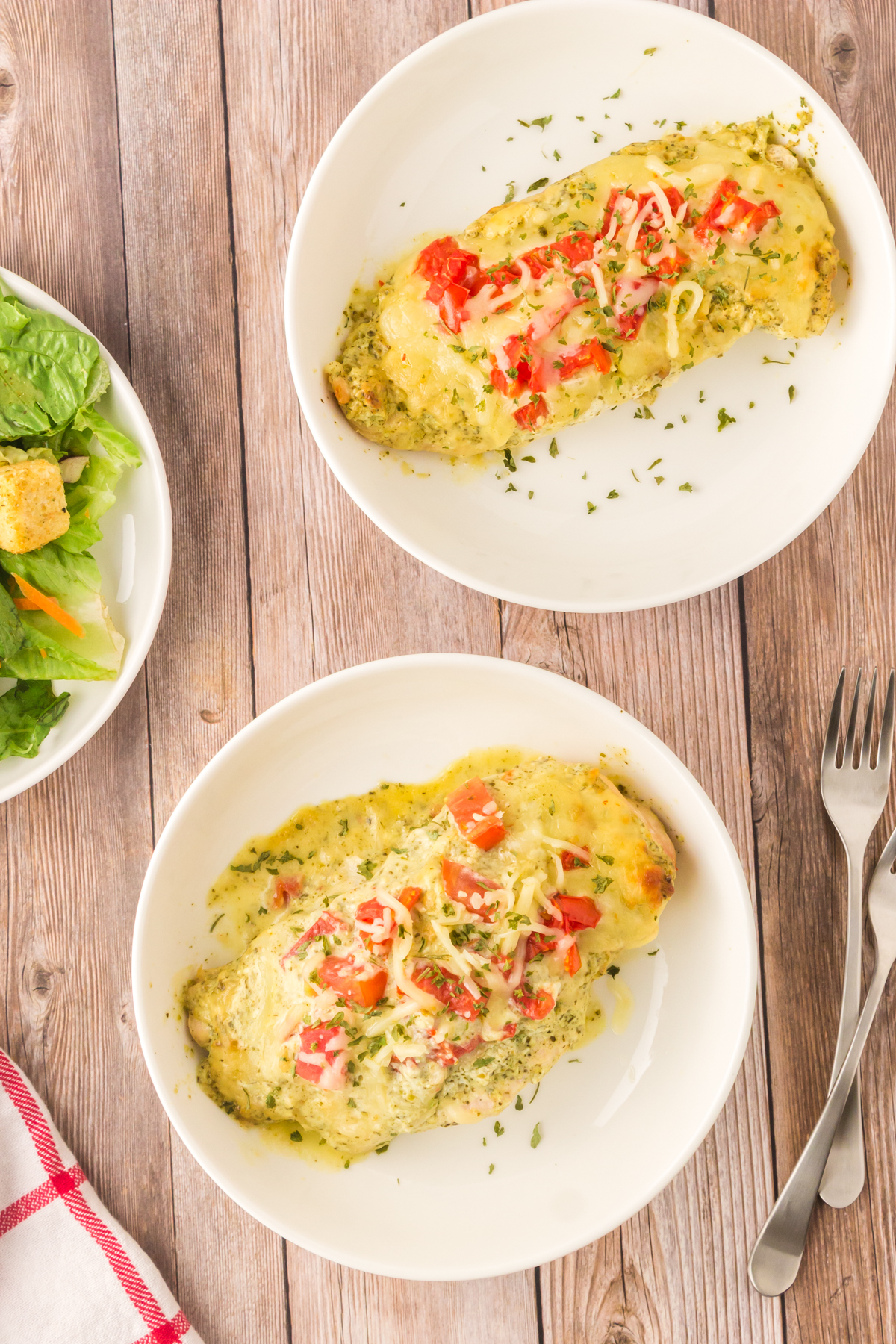 baked pesto chicken on a plate with salad