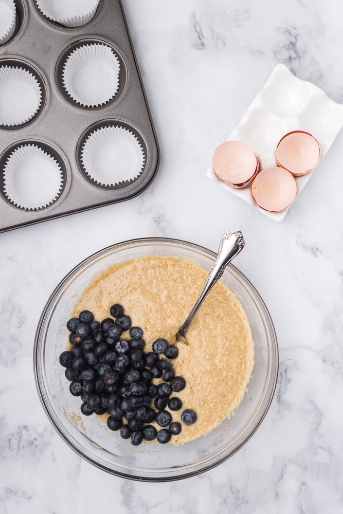 mixing the blueberries into the muffin batter