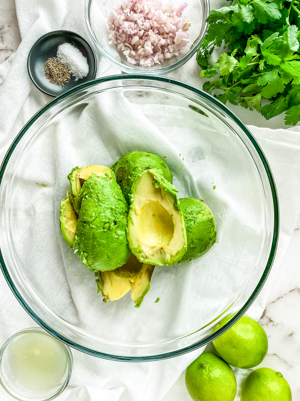 avocado pit removed from avocado halves in a bowl