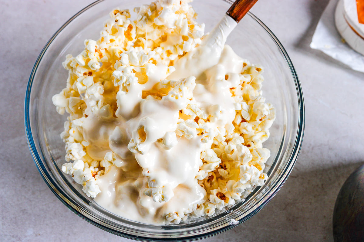 mixing the melted marshmallow mixture into the popcorn.