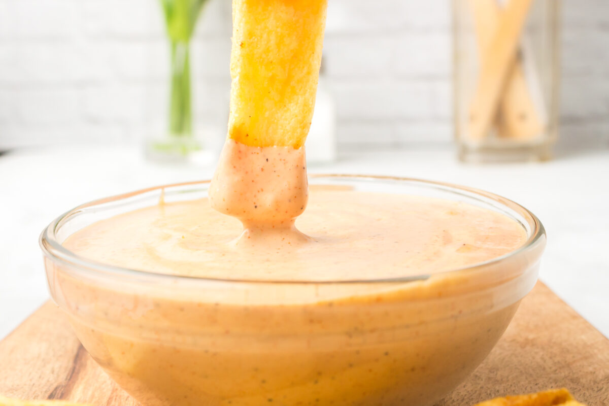 french fries dipped into spicy honey mustard sauce