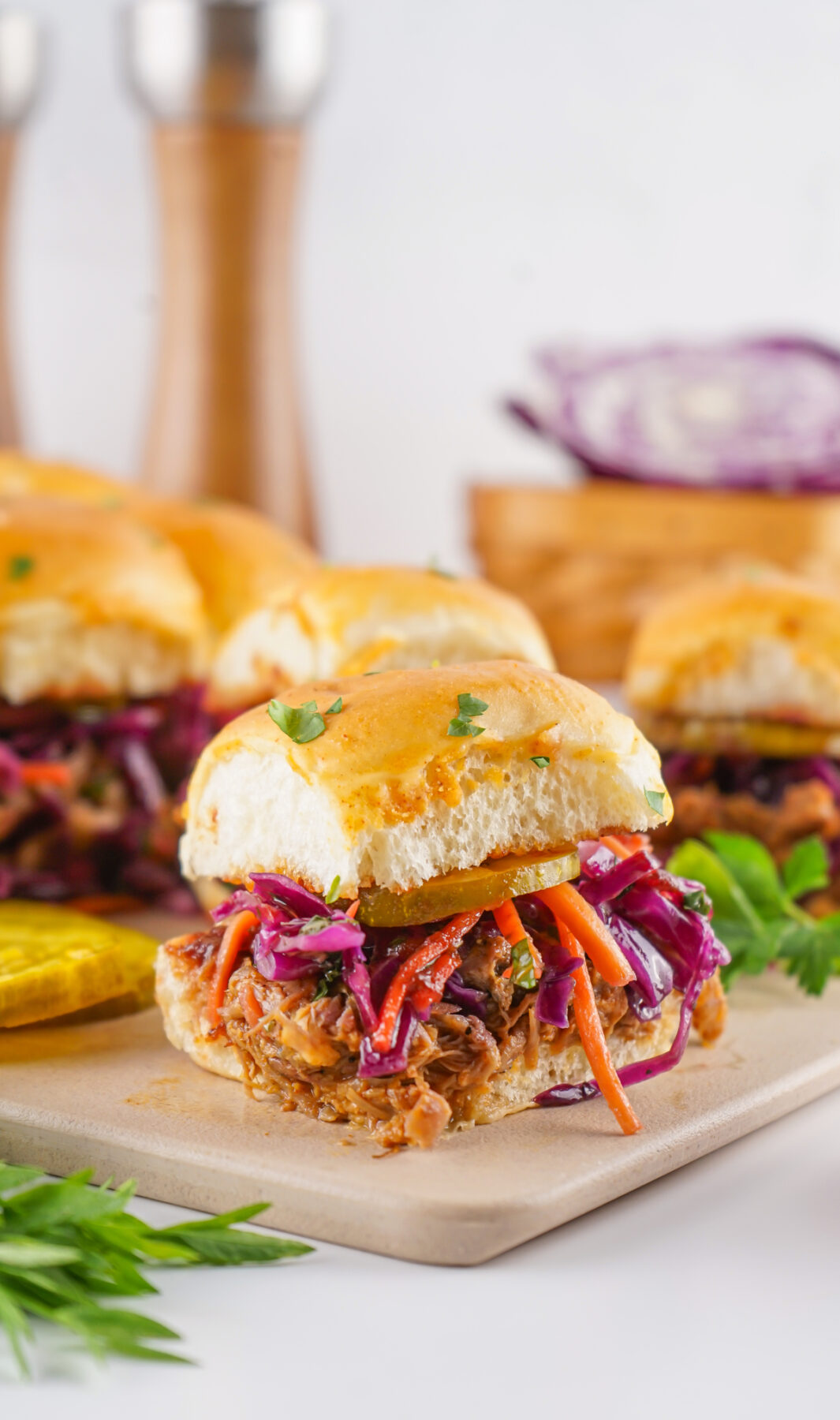 leftover pulled pork sliders on hawaiian sweet rolls on a cutting board