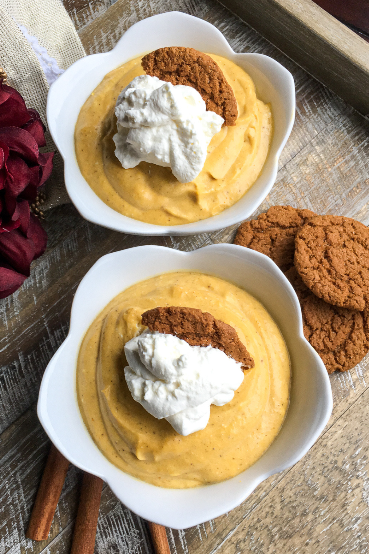 pumpkin mousse topped with whipped cream and a gingersnap cookie